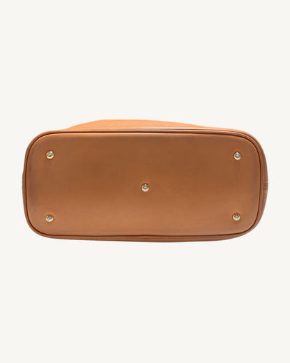 Straight-on view of the MCM tote leather base with five protective metal feet and perimeter piping.